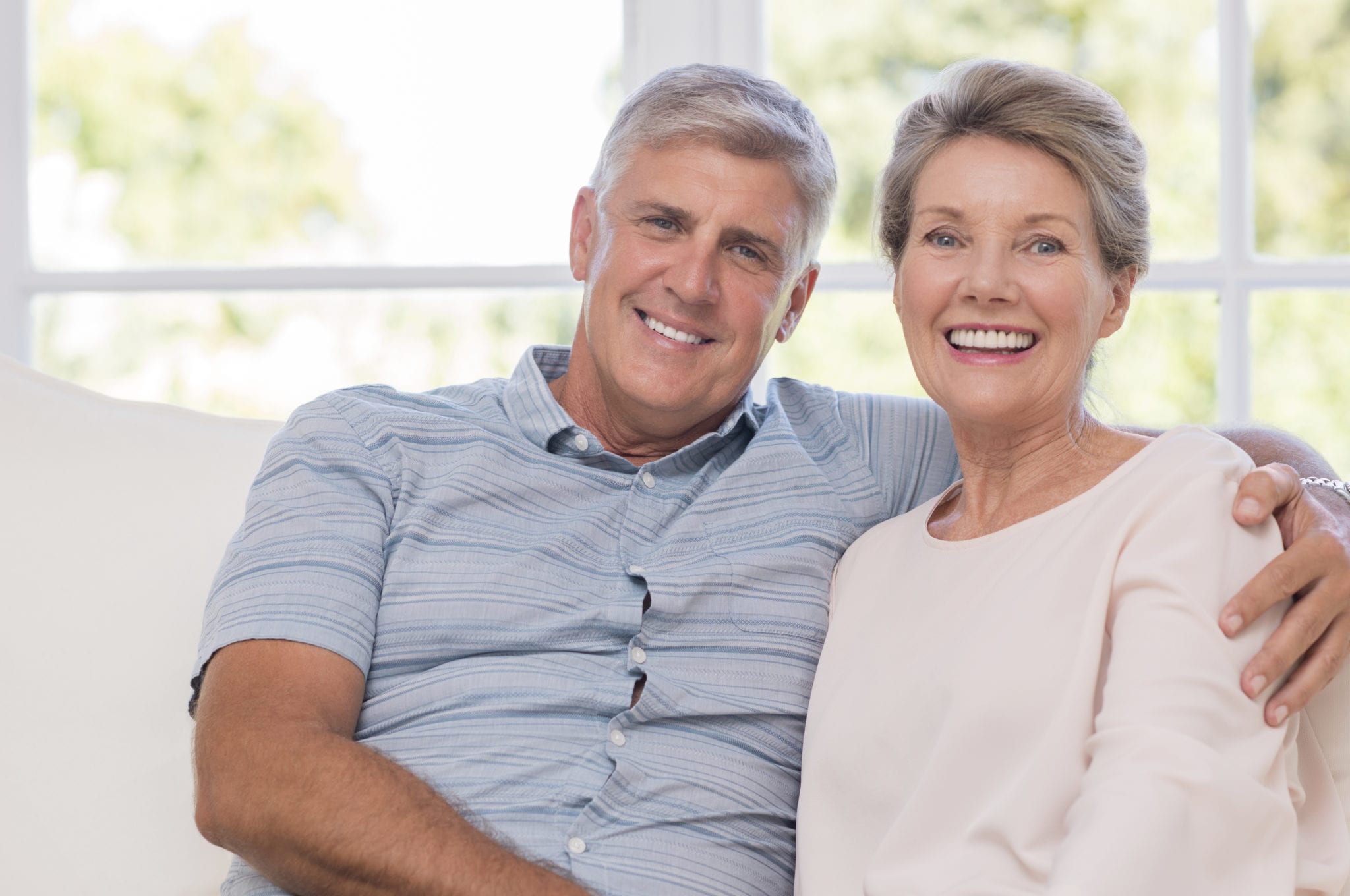 Mature Couple Embracing On Couch Copy