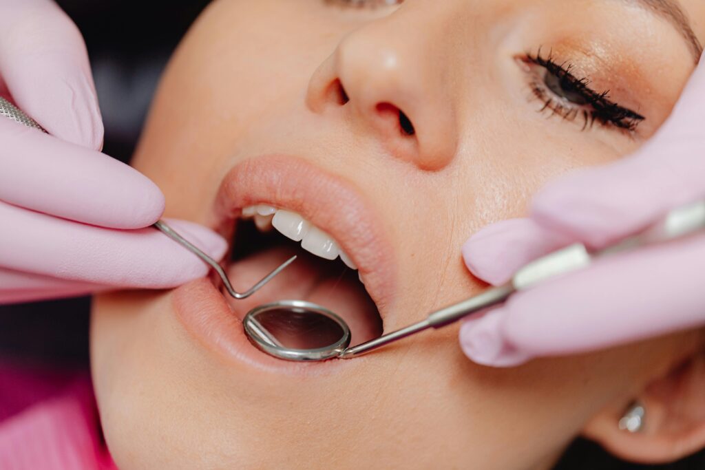 Close-up of a woman's dental checkup with a dentist using tools in a clinic.