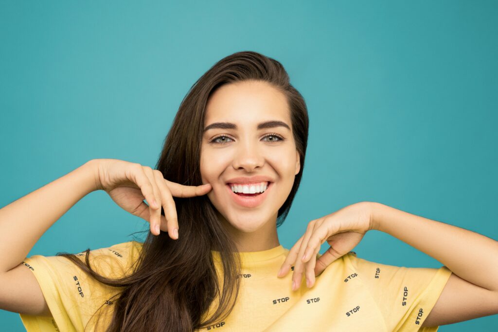 Portrait of a happy, smiling woman posing against a solid blue background.