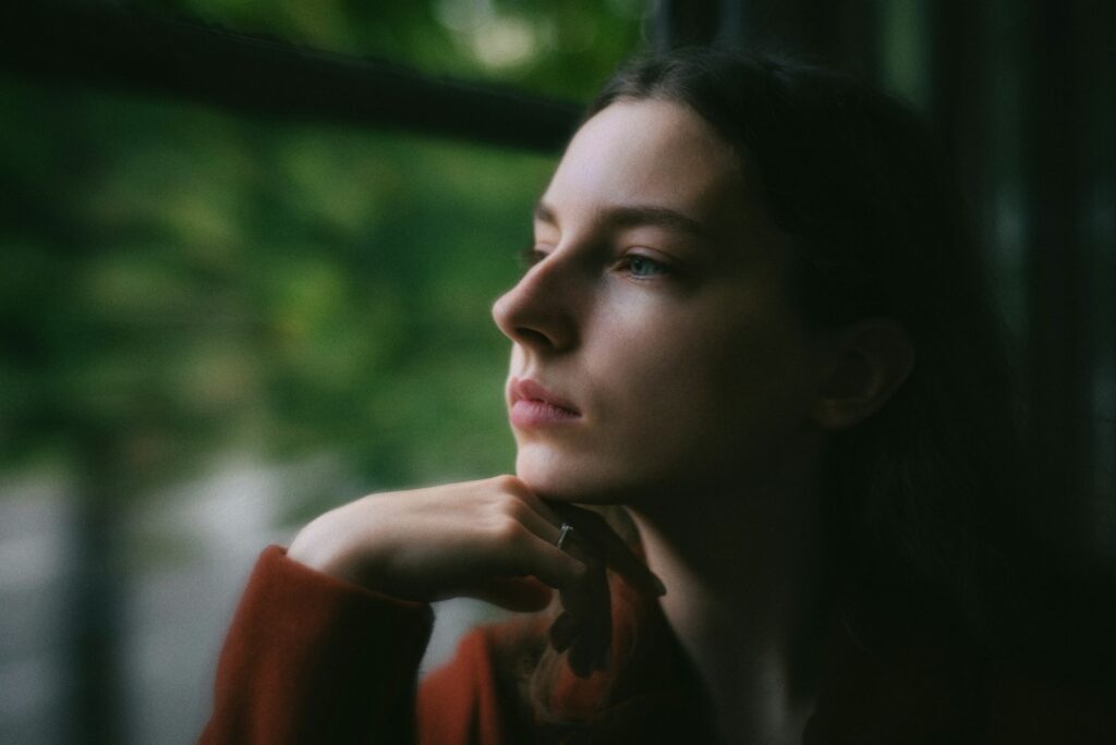 Person thoughtfully considering dental implant treatment in Belmont MA