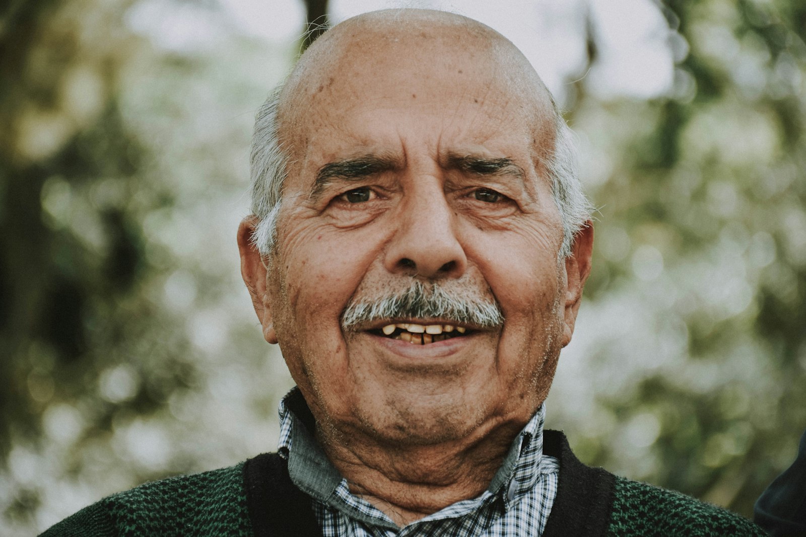 Confident older adult smiling after moving from dentures to implant support in Belmont MA