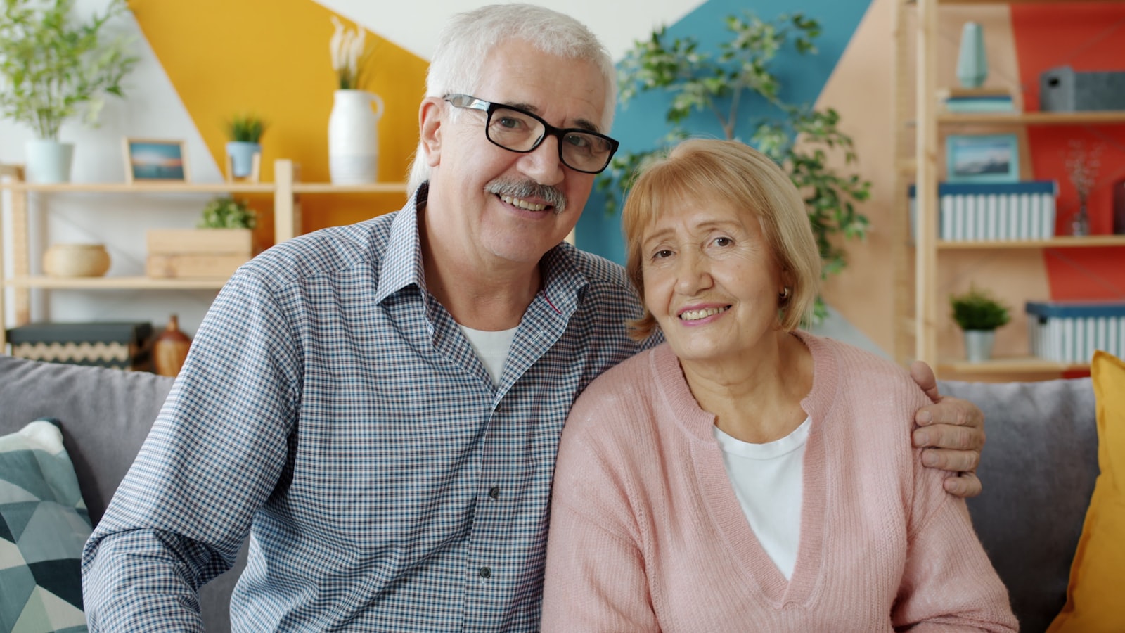 Happy older couple smiling confidently after implant-supported treatment in Belmont MA