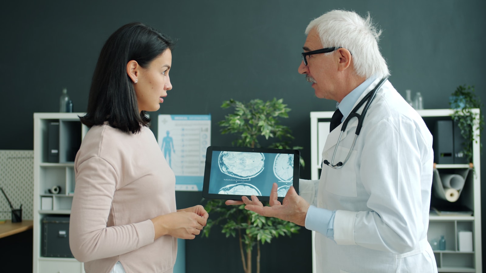 Prosthodontist explaining a dental implant plan clearly to a patient in Belmont MA