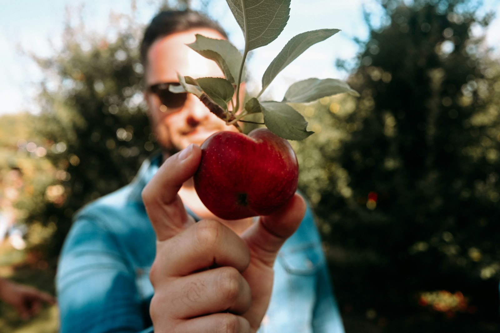 Person biting into an apple thanks to secure snap-in dentures in Belmont MA